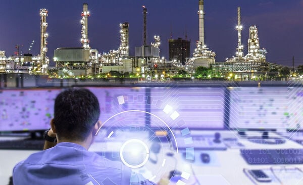 Industrial control room at night with a digital data overlay